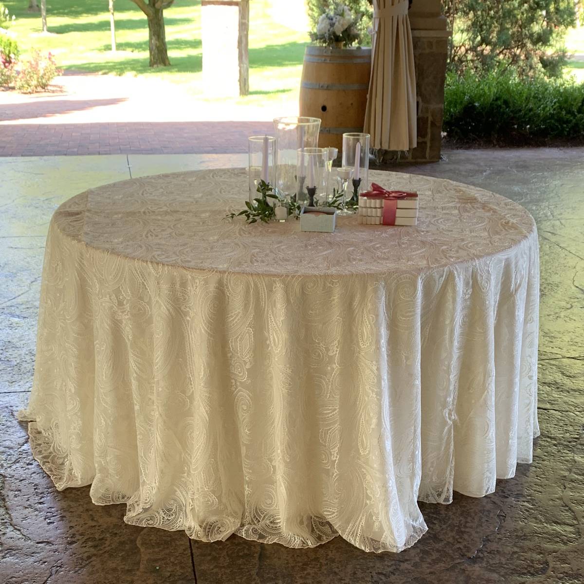 108" Round Ivory Solid Tablecover With 108" Round Ivory Paisley Lace Tablecover On 48" Round Wood Topped Table